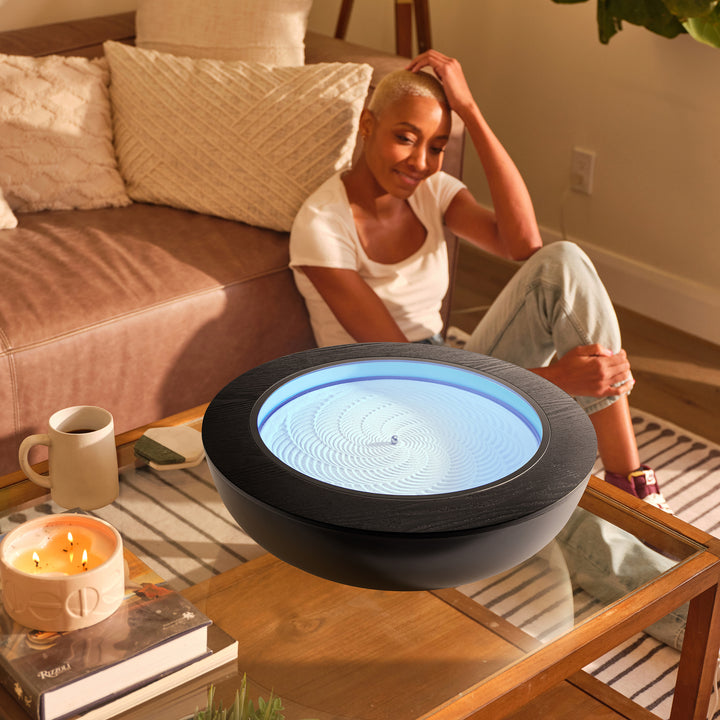 Walnut | a woman looks into the drift 16" with the drift 16" wood ring and practices mindfulness