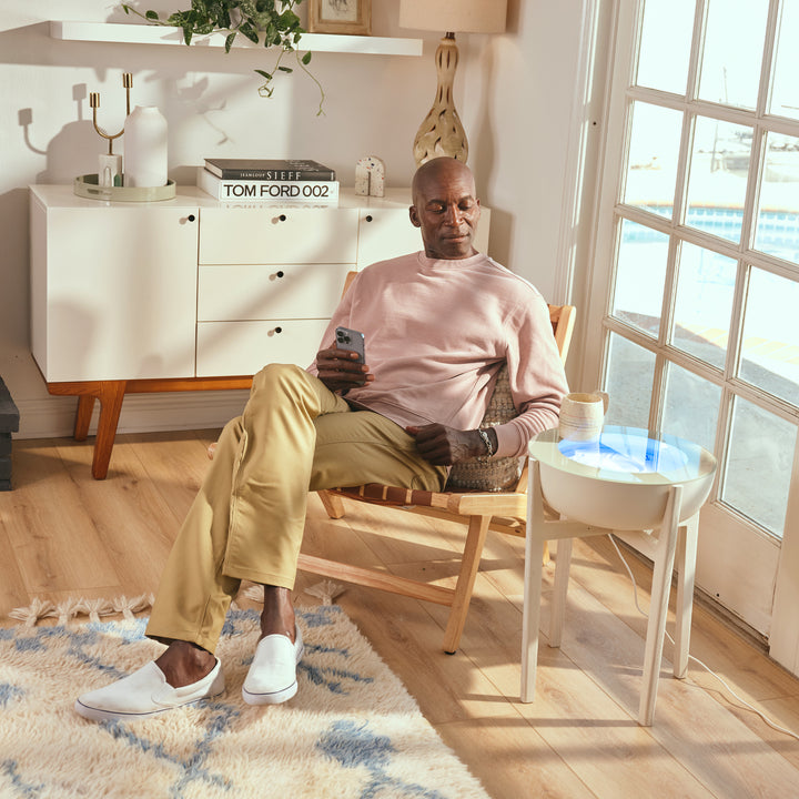 White Wash | drift 16" wood stand displays the drift sand table next to a man while he relaxes in the afternoon