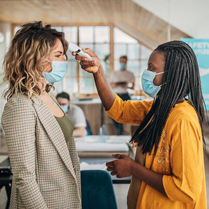 Woman uses the Homedics Non-Contact Infrared Thermometer to take the temperature of woman in office