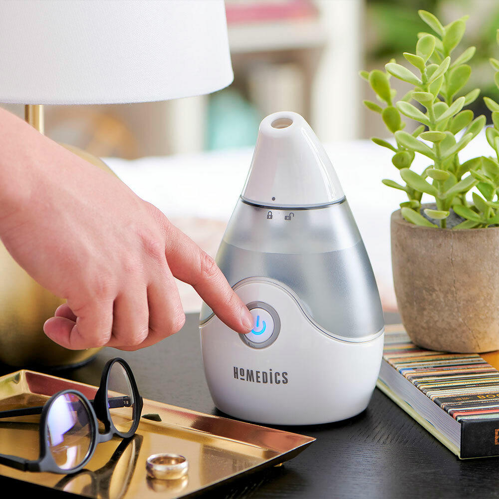 Hand presses power button on the Homedics Personal / Portable Ultrasonic Cool Mist Humidifier