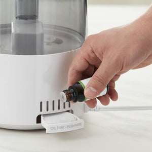 Man adds aromatherapy essential oils to the Homedics TotalComfort Adjustable Mist Ultrasonic Humidifier