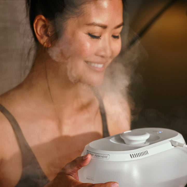 The woman breathes in mist from the Homedics® Ultrasonic Humidifier CMTF14