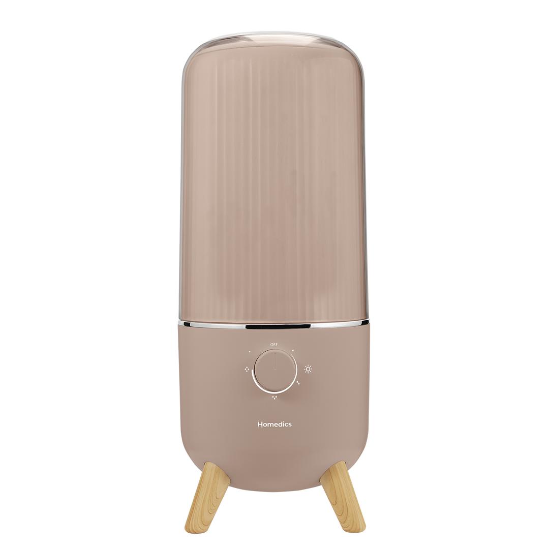 Taupe | Homedics® Medium Ultrasonic Humidifier is on while woman reclines on the couch