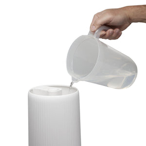 Hand pours water into the tank of the Homedics TotalComfort Deluxe Tower Ultrasonic Humidifier