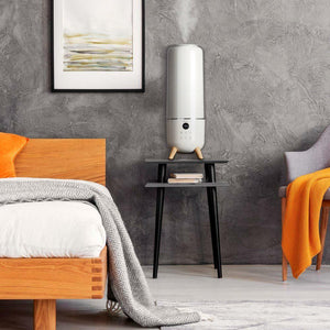 Homedics TotalComfort Deluxe Tower Ultrasonic Humidifier on table in bedroom powered on
