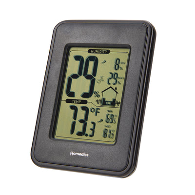 Homedics Indoor Humidity Monitor sits on living room table as couple sits on couch
