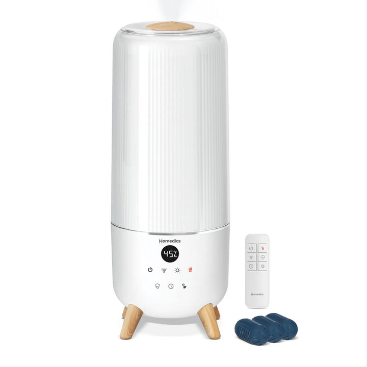 Image of a woman using the Homedics® Warm & Cool Mist Ultrasonic Humidifier while working.