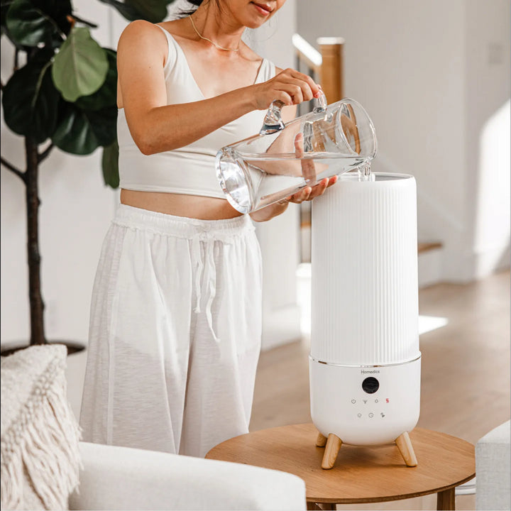 Lifestyle shot featuring theHomedics® Warm & Cool Mist Ultrasonic Humidifier in use.