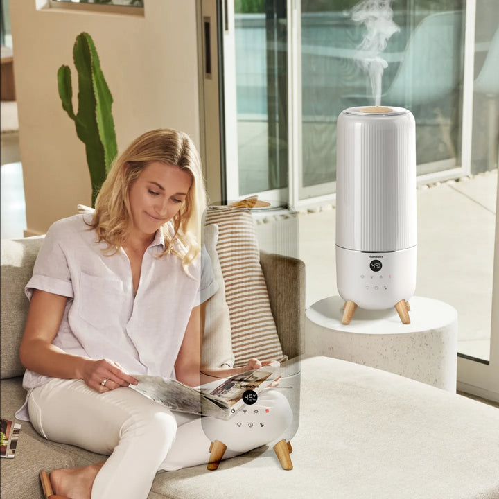 Image of a woman using the Homedics® Warm & Cool Mist Ultrasonic Humidifier while working.