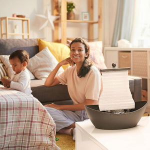 Woman smiles next to the Homedics White Waters Relaxation Fountain on table