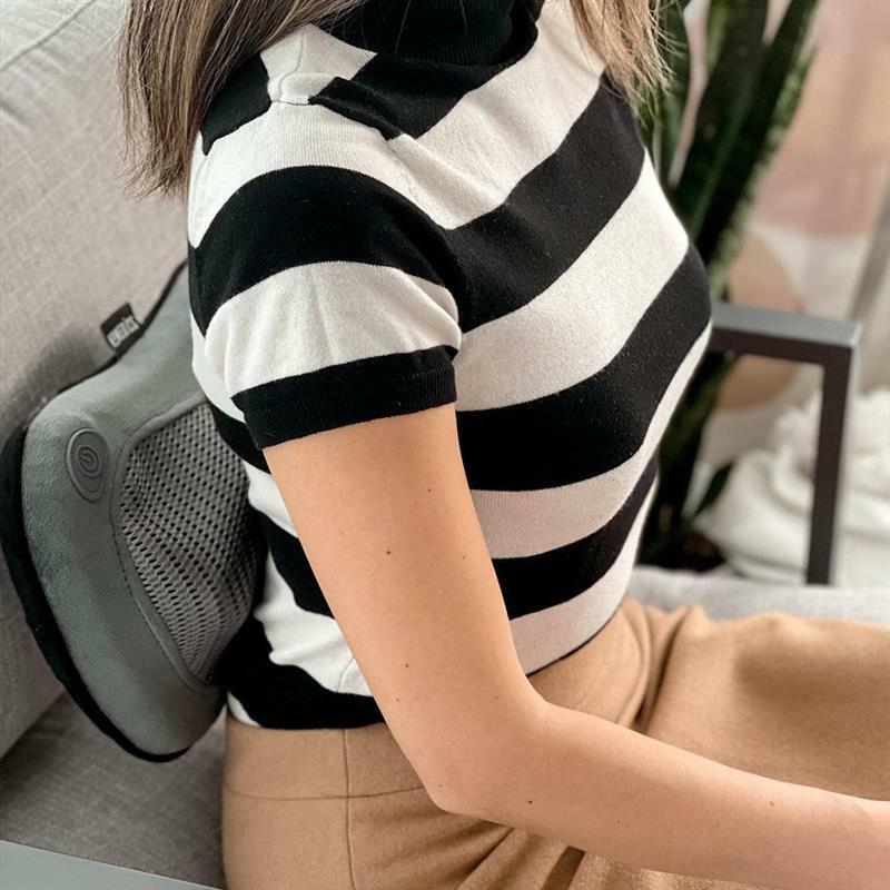 Woman sitting in chair enjoys mid back massage from the Homedics Cordless Shiatsu Massage Pillow with Heat
