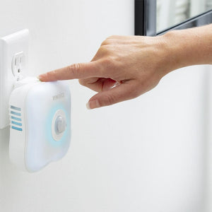 Hand turns on power to the Homedics TotalClean Personal UV Air Sanitizer while attached to wall outlet
