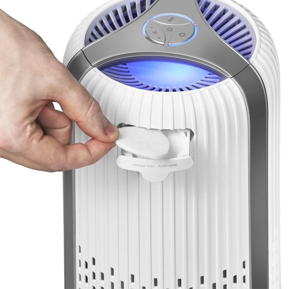 White | Hand adds essential oil pad to the white Homedics TotalClean 4-in-1 Small Room Air Purifier