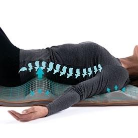 Side view of woman laying on the Homedics Air Compression Back Stretching Mat with graphics