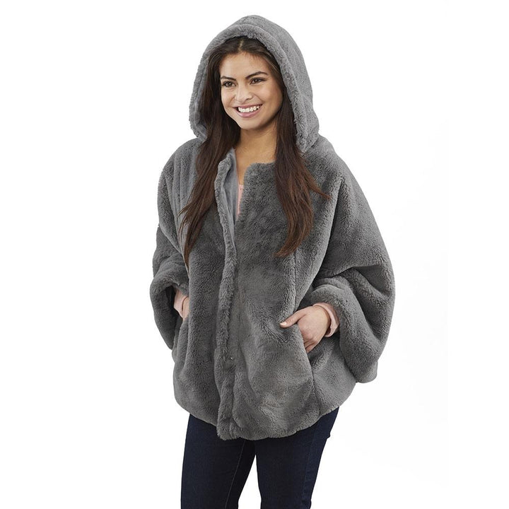 Smiling woman stands while wearing the Homedics Cordless Massaging Cape with Vibration and Soothing Heat