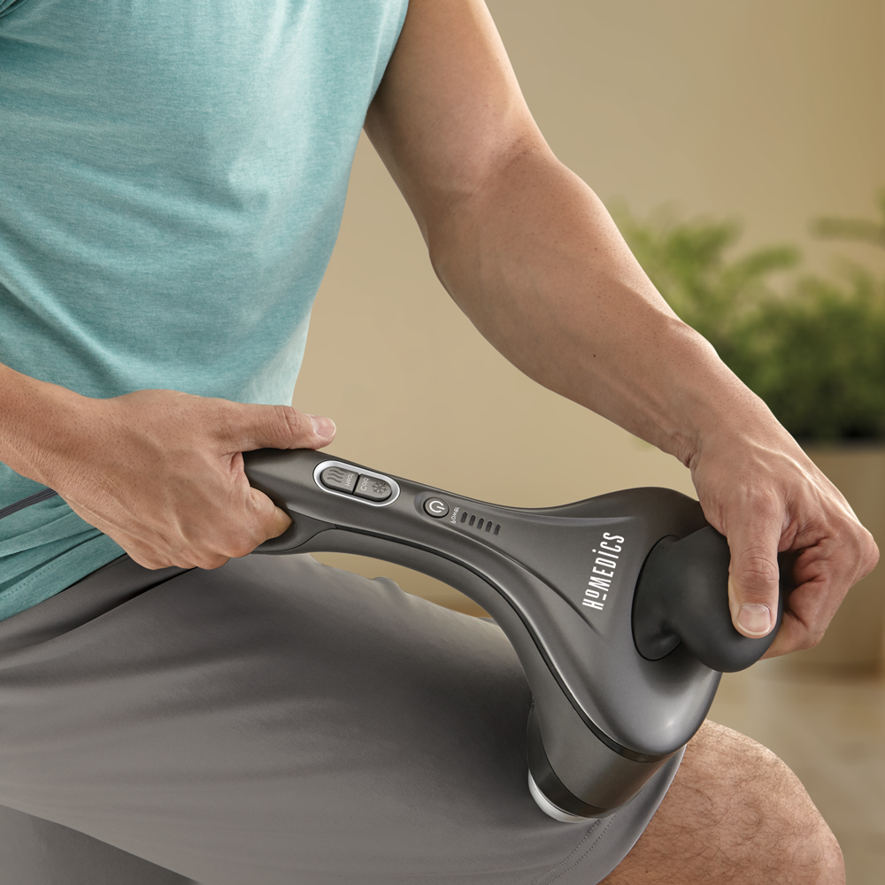 Man holds Homedics Dual Temp Percussion Pro Hot and Cold Massager to thigh