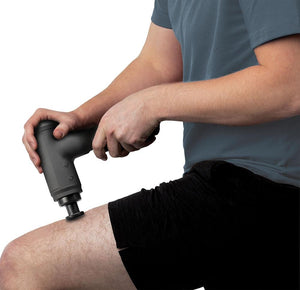 Man massages left quad with the Homedics Therapist Select Percussion Massager