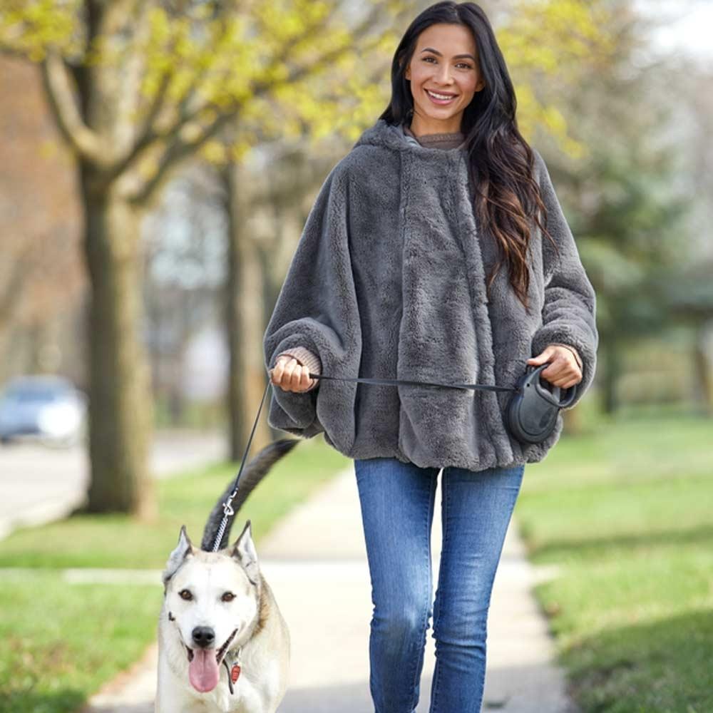 Woman walks down while wearing the Homedics Cordless Massaging Cape with Vibration and Soothing Heat