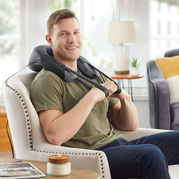 Man in green shirt sits in chair while enjoying a massage from the Homedics Pro Therapy Elite - Shiatsu and Vibration Neck Massager with Heat