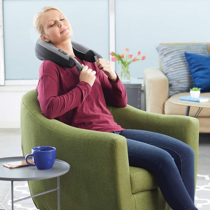 Woman relaxes in chair while enjoying neck massage from the Homedics Pro Therapy Vibration Neck Massager with Heat