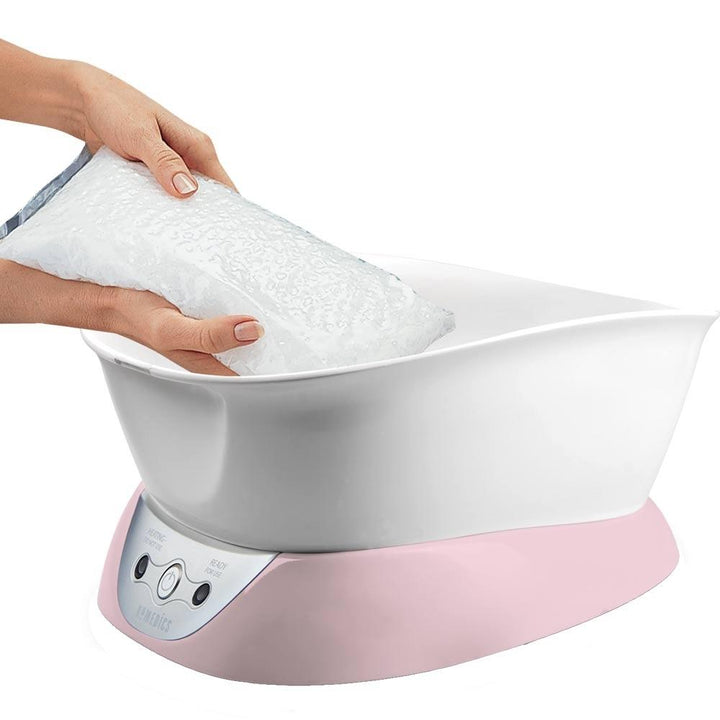 Paraffin wax being added to the Homedics Pink ParaSpa Plus Paraffin Bath
