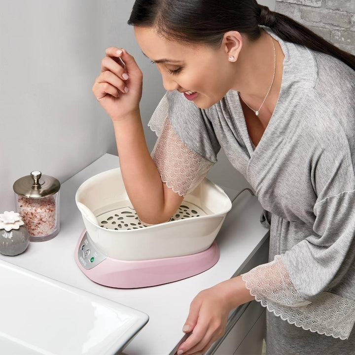 Woman places elbow inside the Homedics Pink ParaSpa Plus Paraffin Bath