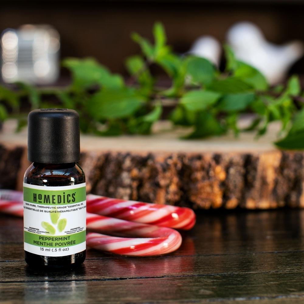 Homedics Peppermint Essential Oil 15 ml on table next to candy canes