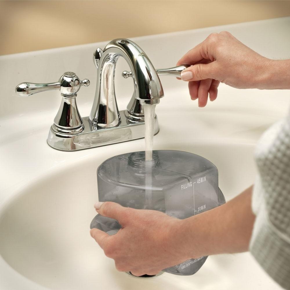 Woman fills Homedics HOME Touch Perfect Steam Deluxe Commercial Garment Steamer tank with water from faucet