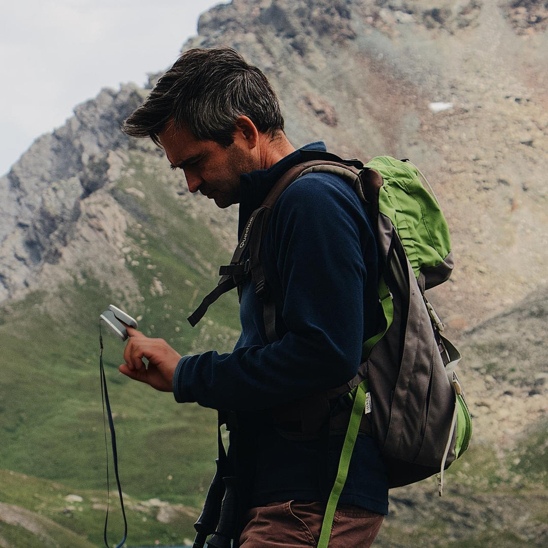 Man checks his pulse with the Homedics Premium Pulse Oximeter while hiking
