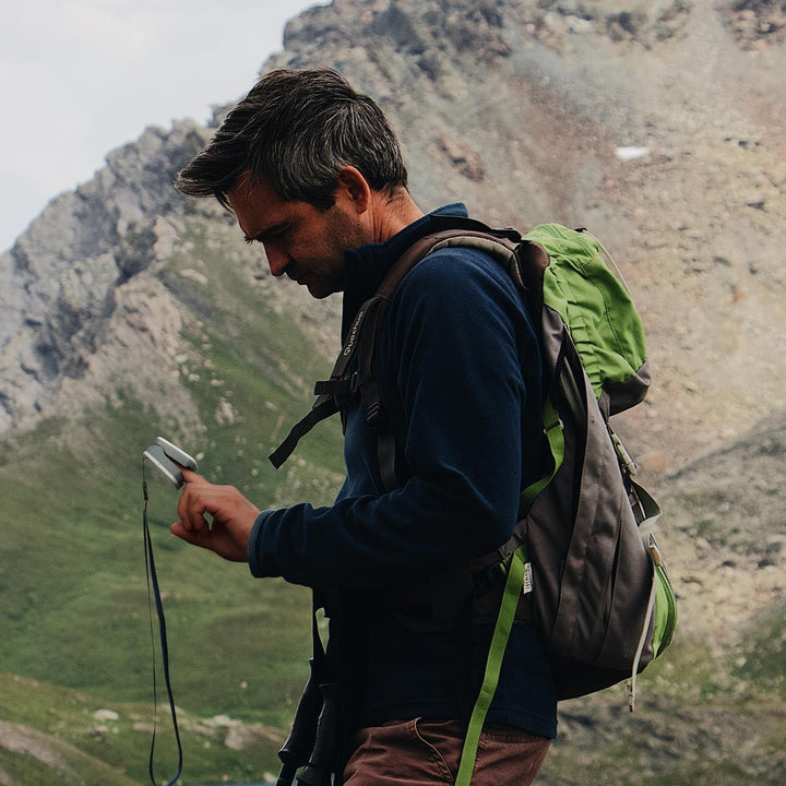 Man checks his pulse with the Homedics Premium Pulse Oximeter while hiking