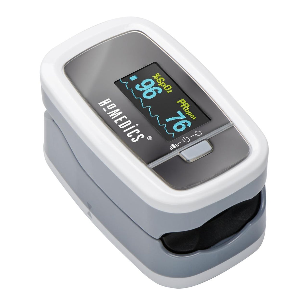 Woman writes at computer desk while wearing Homedics Premium Pulse Oximeter around neck