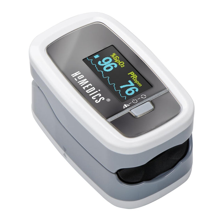 Woman writes at computer desk while wearing Homedics Premium Pulse Oximeter around neck