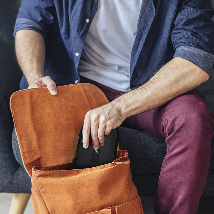 Black | Man puts black Homedics UV CLEAN Portable Phone Sanitizer in travel bag