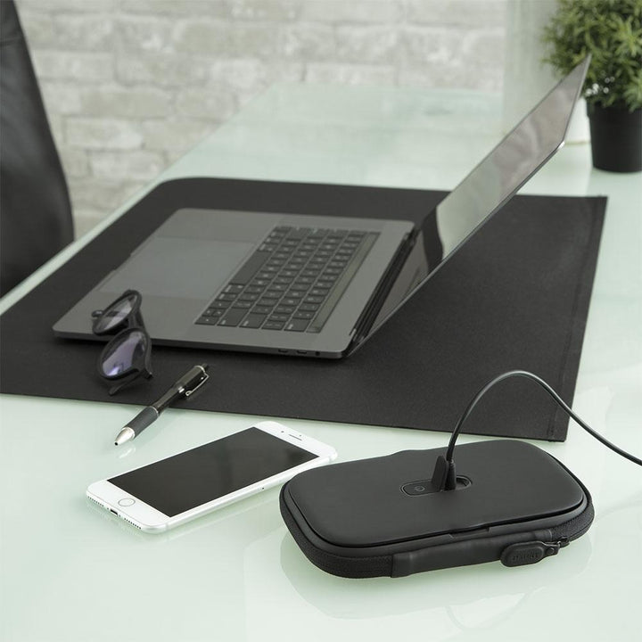 Black | Black Homedics UV CLEAN Portable Phone Sanitizer charging next to laptop on computer desk