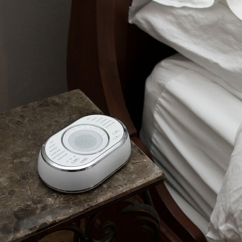 Homedics SoundSpa Ultra Portable Rechargeable Sound Machine on end table next to bed