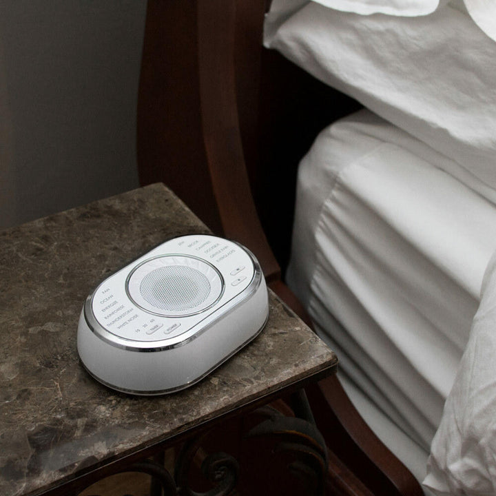 Homedics SoundSpa Ultra Portable Rechargeable Sound Machine on end table next to bed