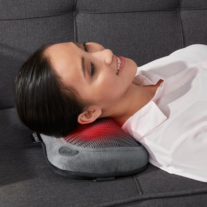 Woman laying across sofa enjoys neck massage from Homedics Cordless Shiatsu Massage Pillow with Heat