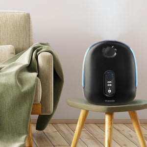 Homedics TotalComfort Deluxe Ultrasonic Humidifier sitting on small table next to couch