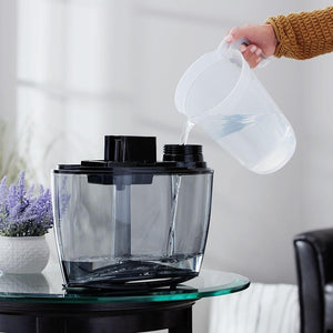 Hand filling the Homedics TotalComfort Plus Ultrasonic Humidifier tank with water