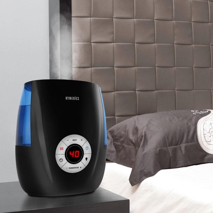 Homedics Warm and Cool Mist Ultrasonic Humidifier on night stand next to bed