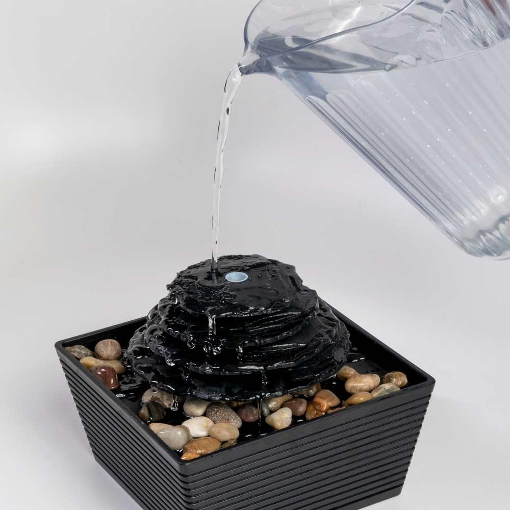 Pouring water onto Homedics Envirascape Entrance Tabletop Relaxation Fountain from pitcher