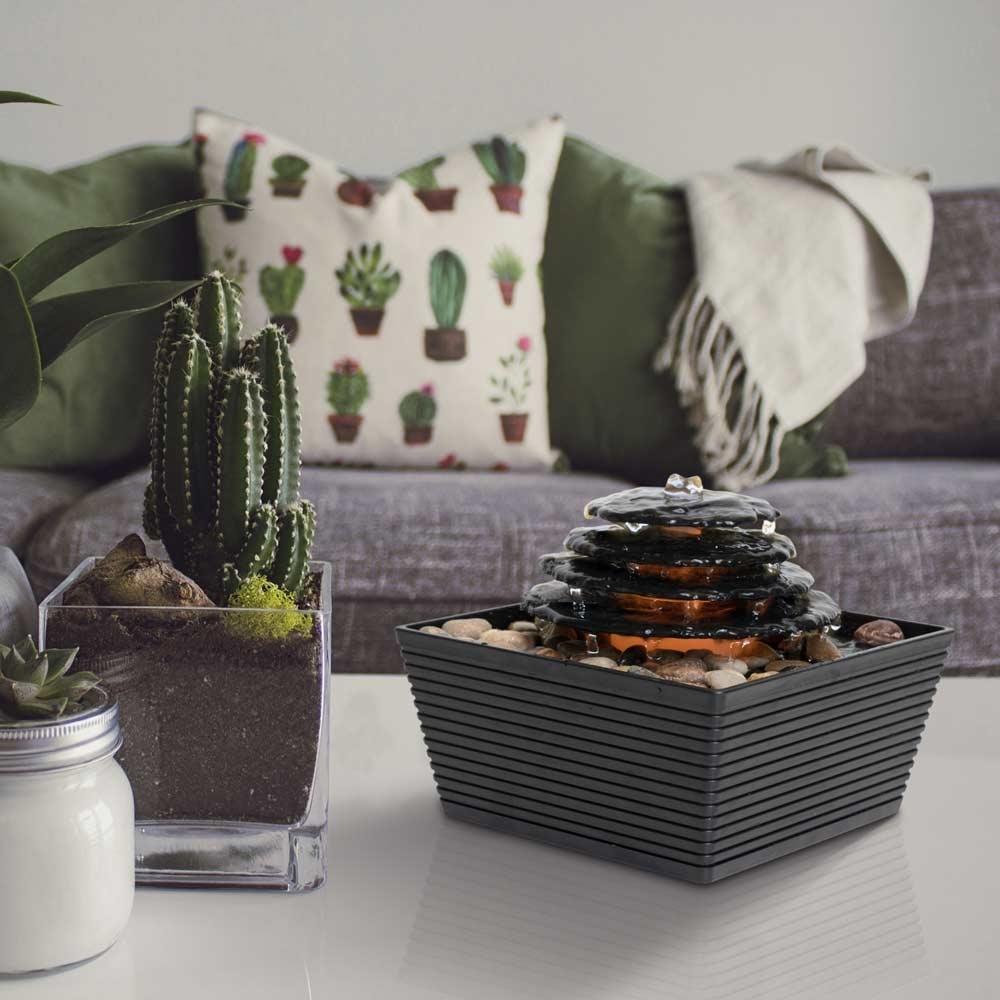 Homedics Envirascape Entrance Tabletop Relaxation Fountain next to plant on coffee table